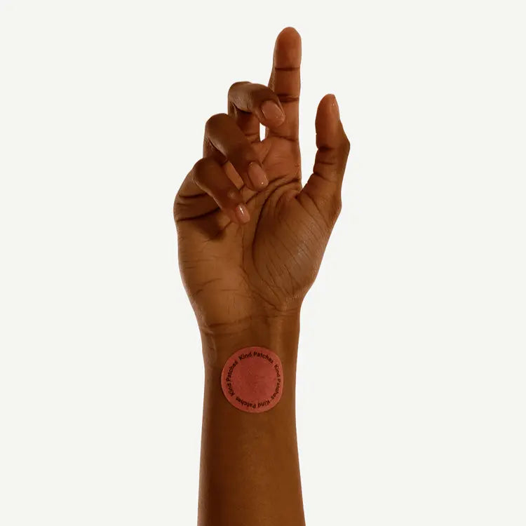 Hand showing a GLP-1 patch sticker on it on a white background